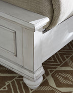 White panel bed corner leg and side panel with inset molding detail.