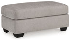 Light gray flannel ottoman with dark legs, padded seat, rounded top