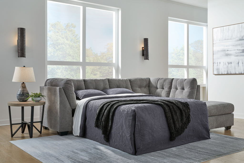 Gray sofa sleeper in open bed position with quilted back and armrests