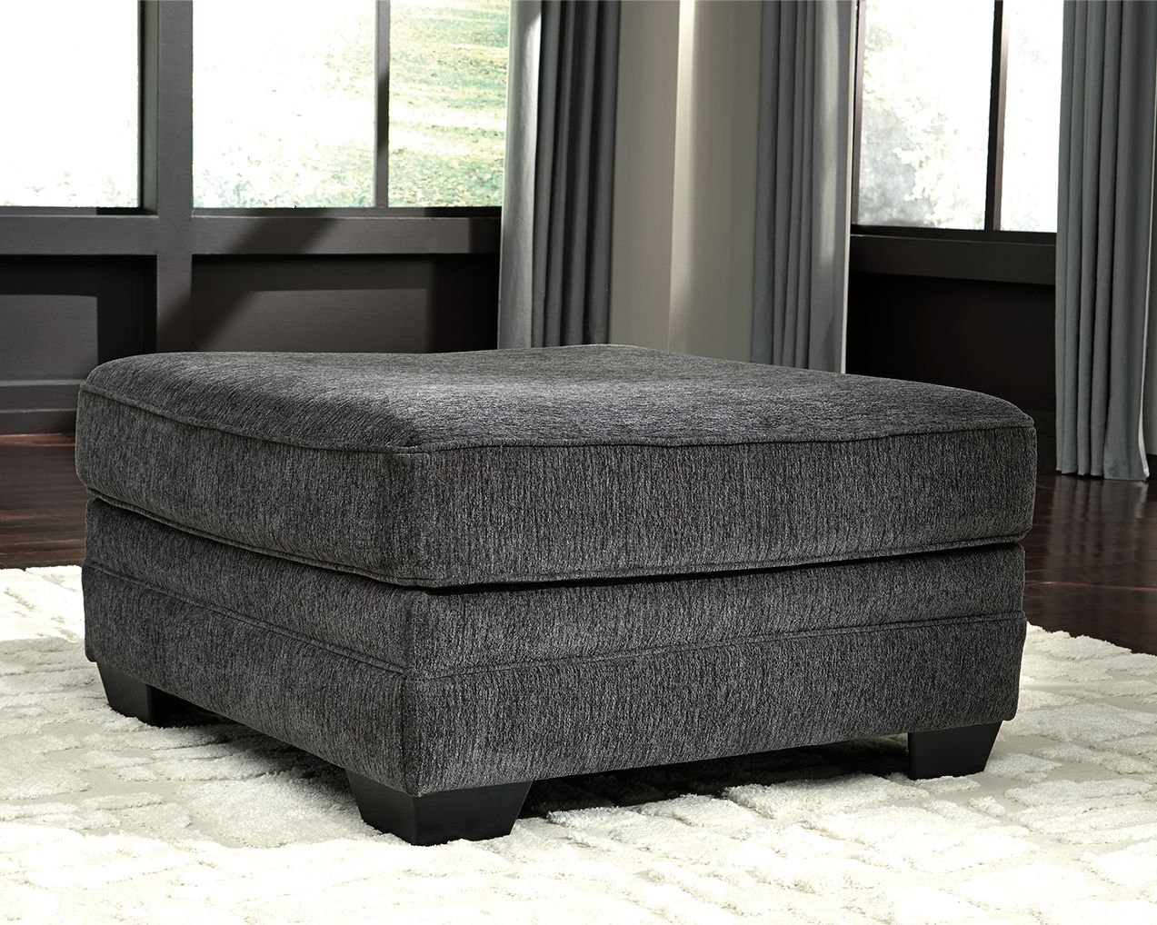 Slate gray upholstered accent ottoman with rounded top and square black legs