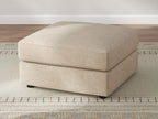 Sand upholstered ottoman with rounded-corner top and short dark legs