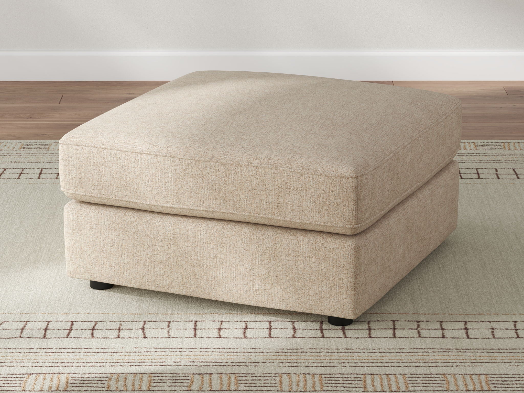 Sand upholstered ottoman with rounded-corner top and short dark legs