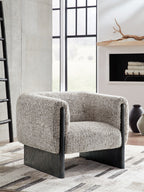 Accent chair in oatmeal boucle with dark wood legs and curved padded armrests.