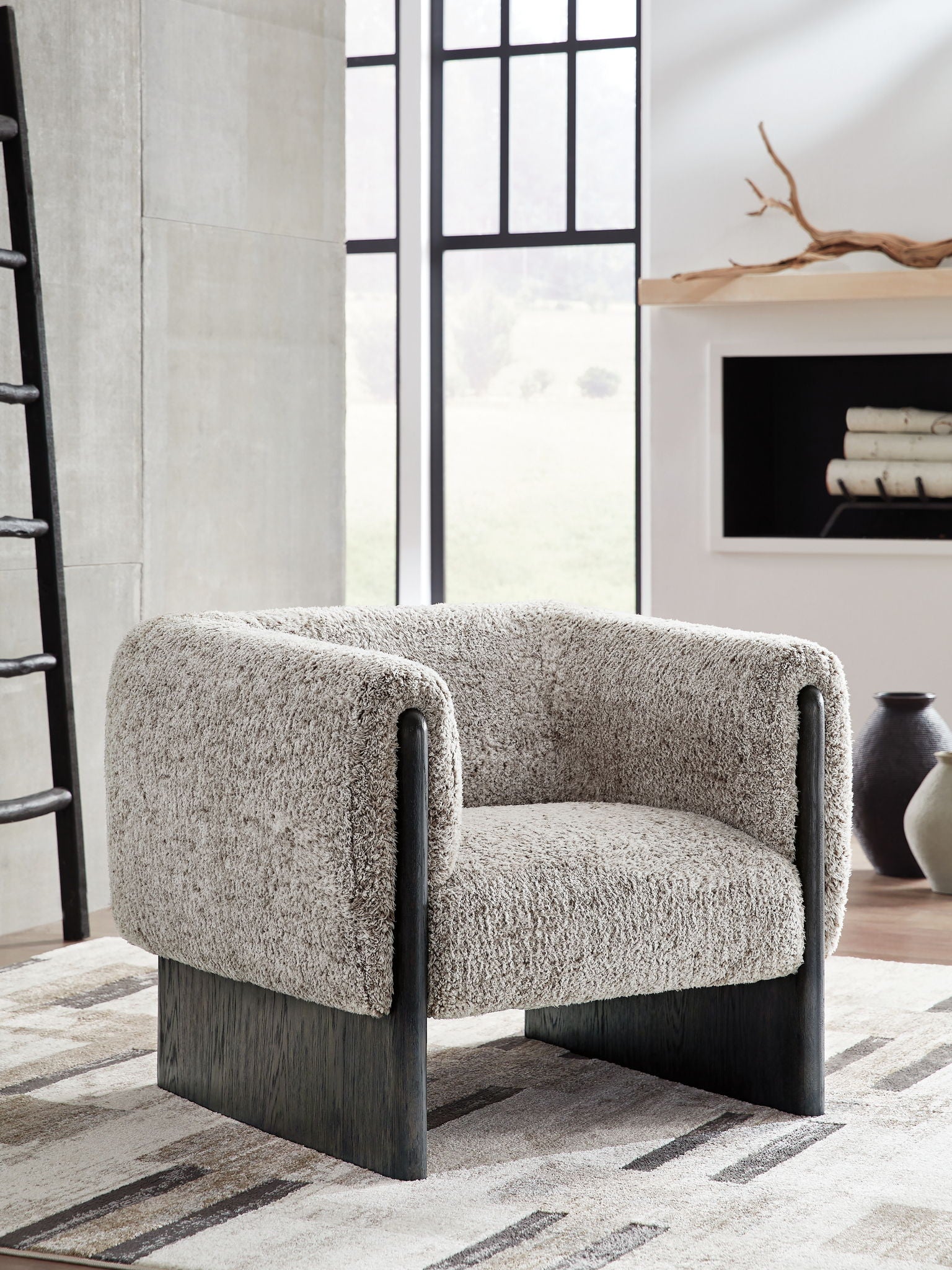 Accent chair in oatmeal boucle with dark wood legs and curved padded armrests.