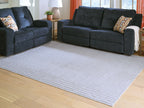 Gray washable rug with subtle raised stripes, laid in a living room floor