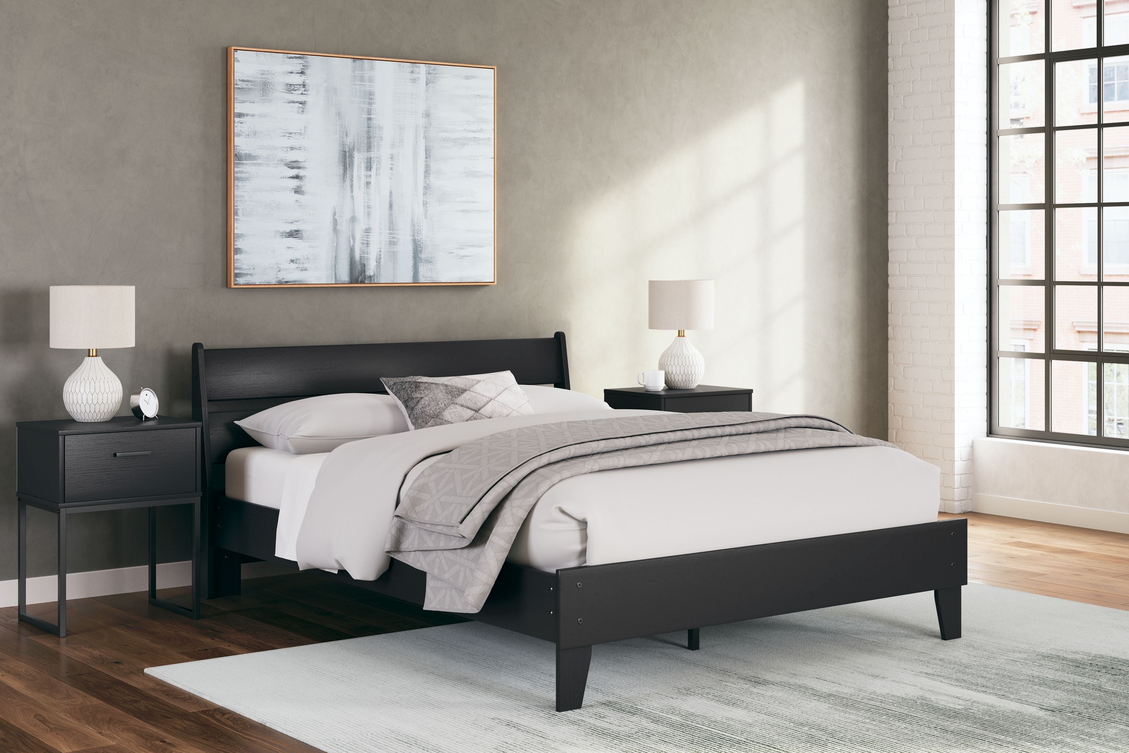 Black panel platform bed with white bedding and gray throw blanket