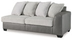 Gray sofa with ribbed striped cushions and three back pillows on a boxy base