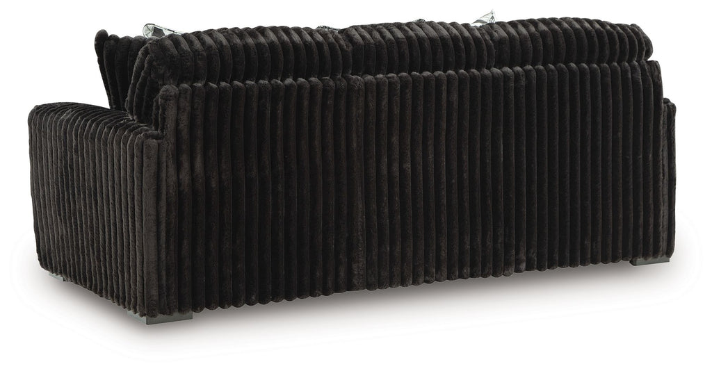 Black corduroy sofa with track arms and a three-seat backrest, no visible cushions.