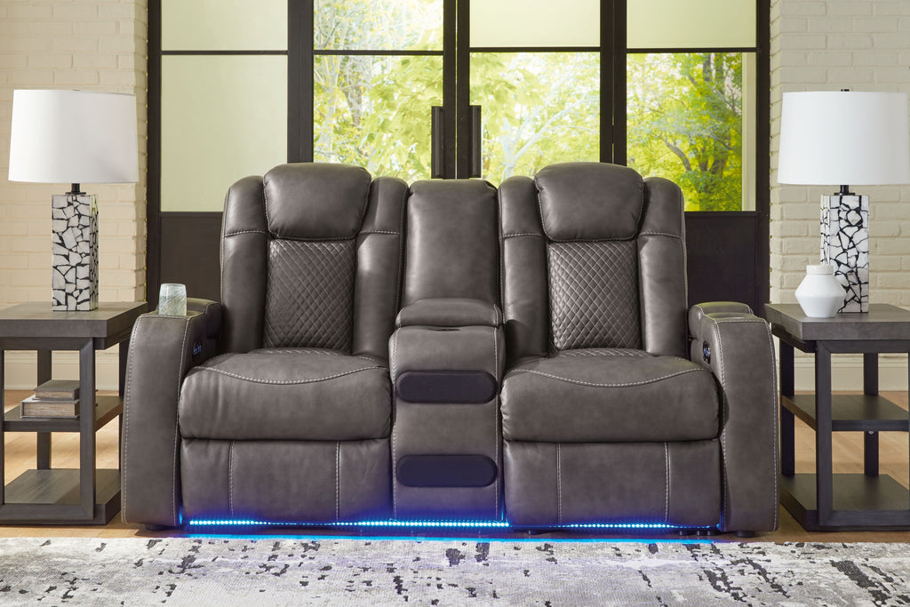 Dark gray power reclining loveseat with padded headrests and center console controls