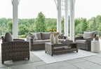 Gray wicker patio seating set with sofa, two chairs, and coffee table