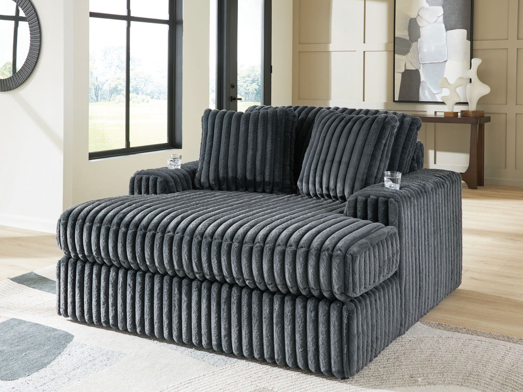 Oversized dark gray corduroy chaise with deep channel tufted upholstery and plush seat