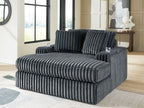 Oversized dark gray corduroy chaise with deep channel tufted upholstery and plush seat