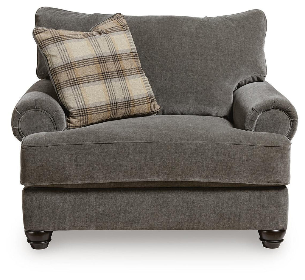 Gray chair-and-a-half with rolled arms and plaid lumbar pillow on the seat