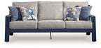 Outdoor sofa with light gray seat cushions and two blue patterned back pillows