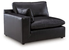 Black leather-look corner chair with tufted seat and back, wide arms, square base.