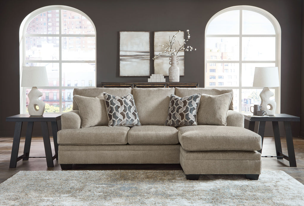 Taupe sofa chaise with four back cushions and two geometric patterned throw pillows