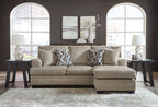 Taupe sofa chaise with four back cushions and two geometric patterned throw pillows