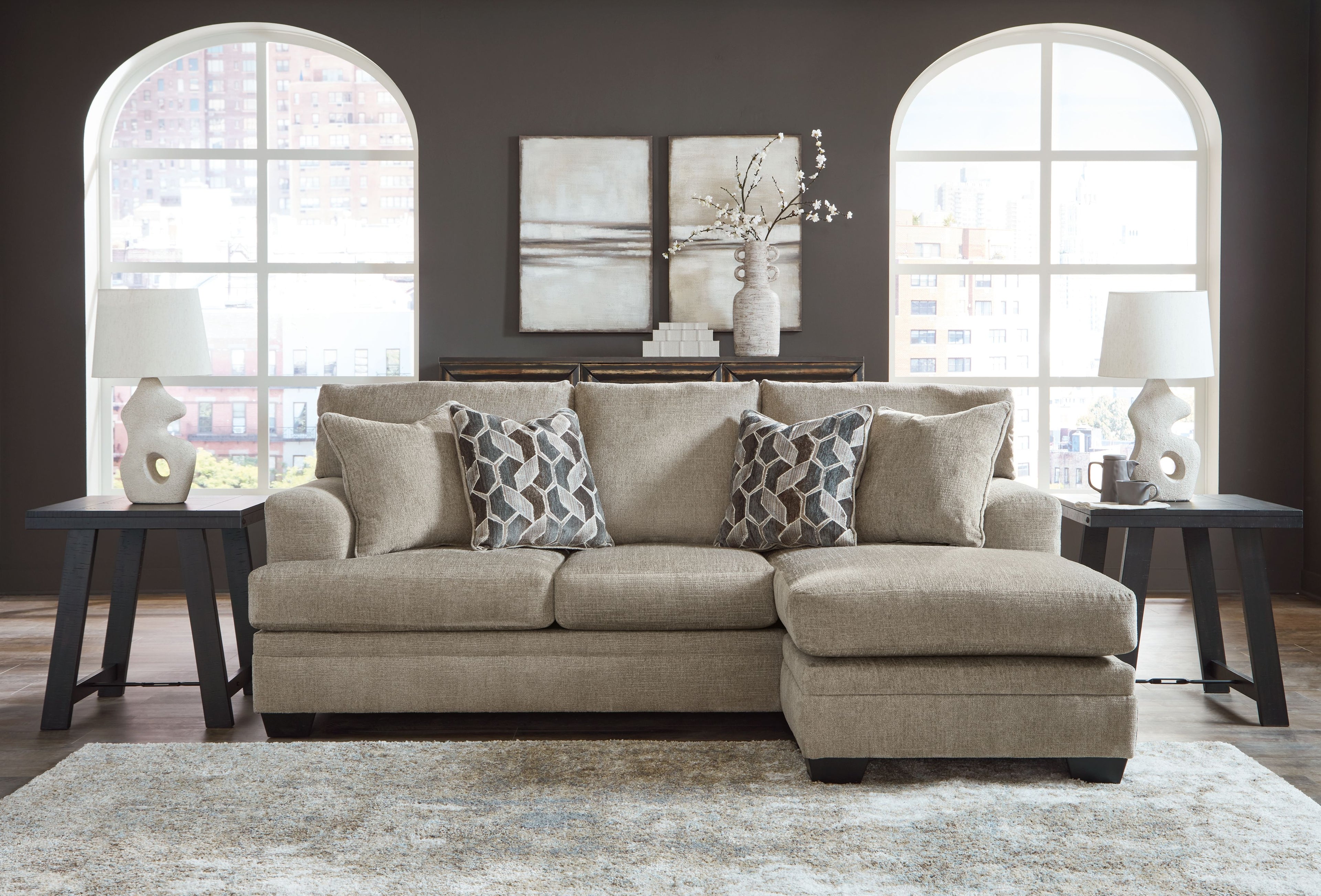 Taupe sofa chaise with four back cushions and two geometric patterned throw pillows