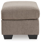 Beige fabric ottoman with cushioned lid and dark tapered block legs