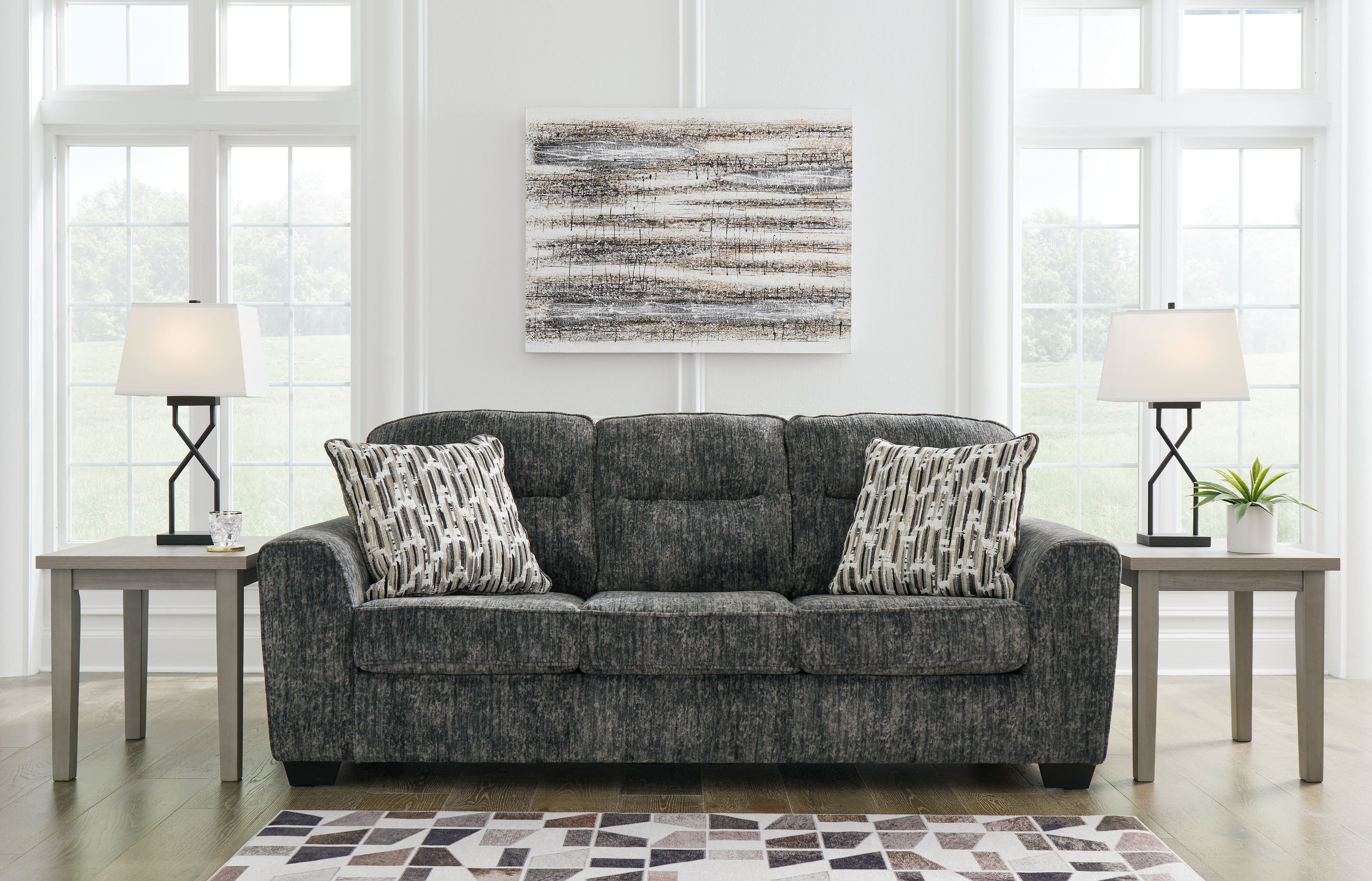 Lonoke sofa in dark gray upholstery with patterned accent pillows