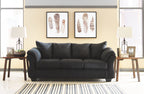 Black sofa with three seat cushions and rolled arms, centered in room