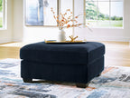 Navy oversized ottoman with ribbed fabric, square padded top, dark legs.