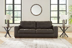 Dark brown tufted sofa with three seat cushions and padded backrest