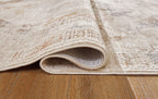 Beige and gray area rug with rolled edge showing low pile thickness.