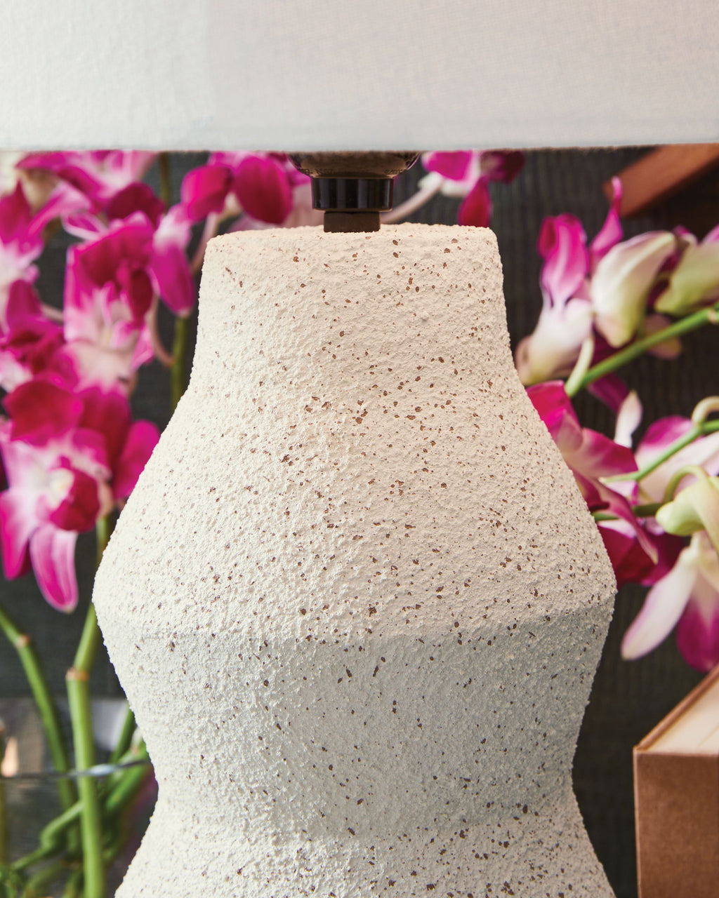 Cream speckled lamp base with black socket and white fabric shade