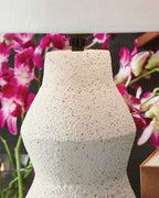 Cream speckled lamp base with black socket and white fabric shade
