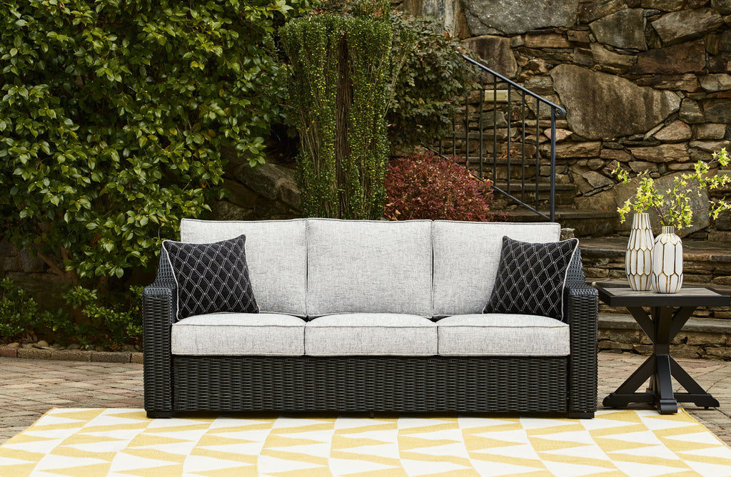 Beachcroft sofa with cushions, dark woven frame, light gray backrests and diamond patterned pillows