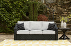 Beachcroft sofa with cushions, dark woven frame, light gray backrests and diamond patterned pillows