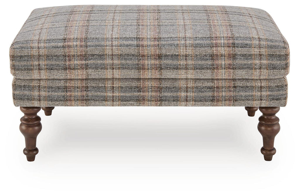 Multi plaid ottoman with smooth upholstered top and dark wooden turned legs