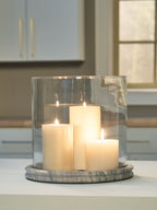 Glass cylinder candle holder with light stone base and four lit candles