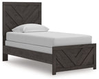 Panel bed with dark gray wood frame, chevron headboard and footboard, white mattress