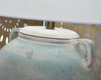 Table lamp with white drum shade and antique green ceramic lid on vase base