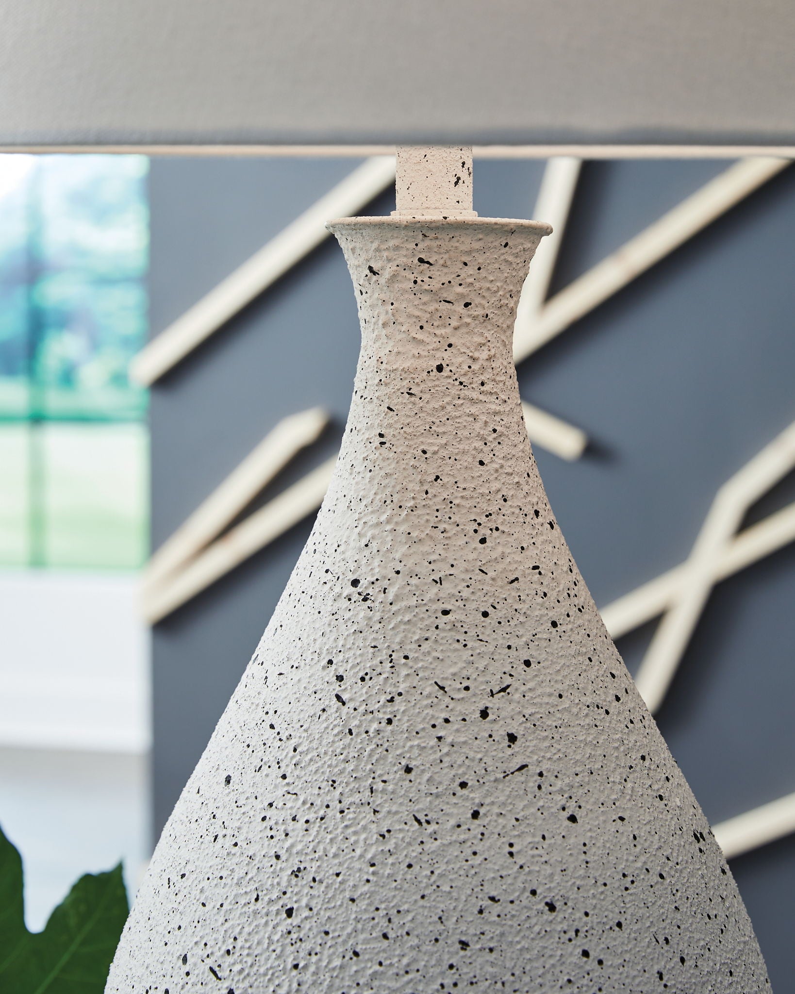Speckled white metal lamp base with narrow neck and finial