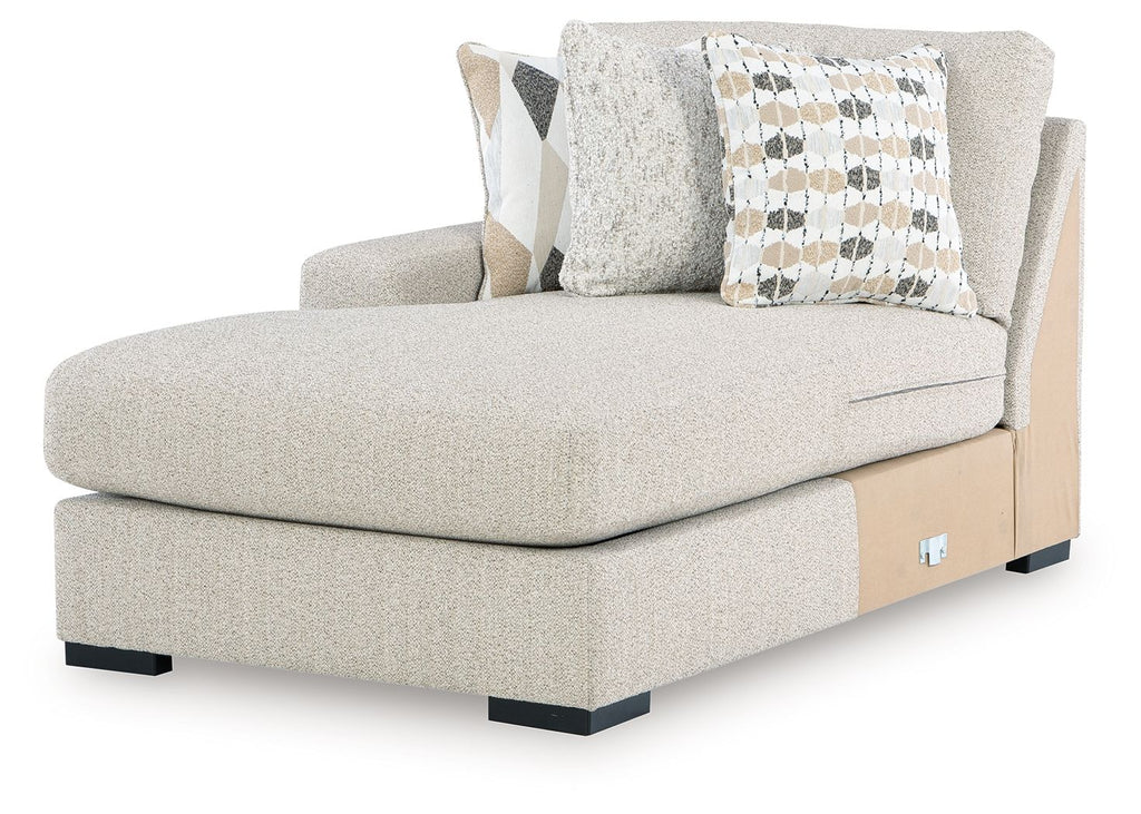 Light upholstered chaise with squared arm, black legs, and decorative checkered and solid pillows