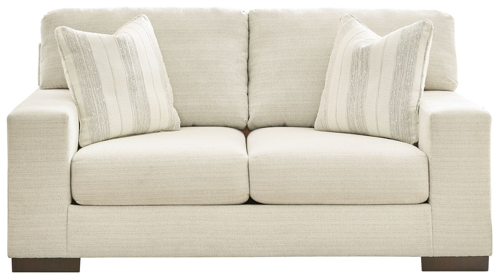 Cream loveseat with rolled arms, two front seat cushions, and three striped pillows