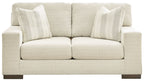 Cream loveseat with rolled arms, two front seat cushions, and three striped pillows