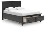Black panel bed with two front drawers and a white upholstered mattress and pillows.