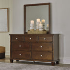 Dark brown dresser with six drawers and tall framed mirror above