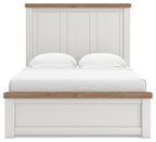 White panel bed frame with paneled headboard and light wood top rail