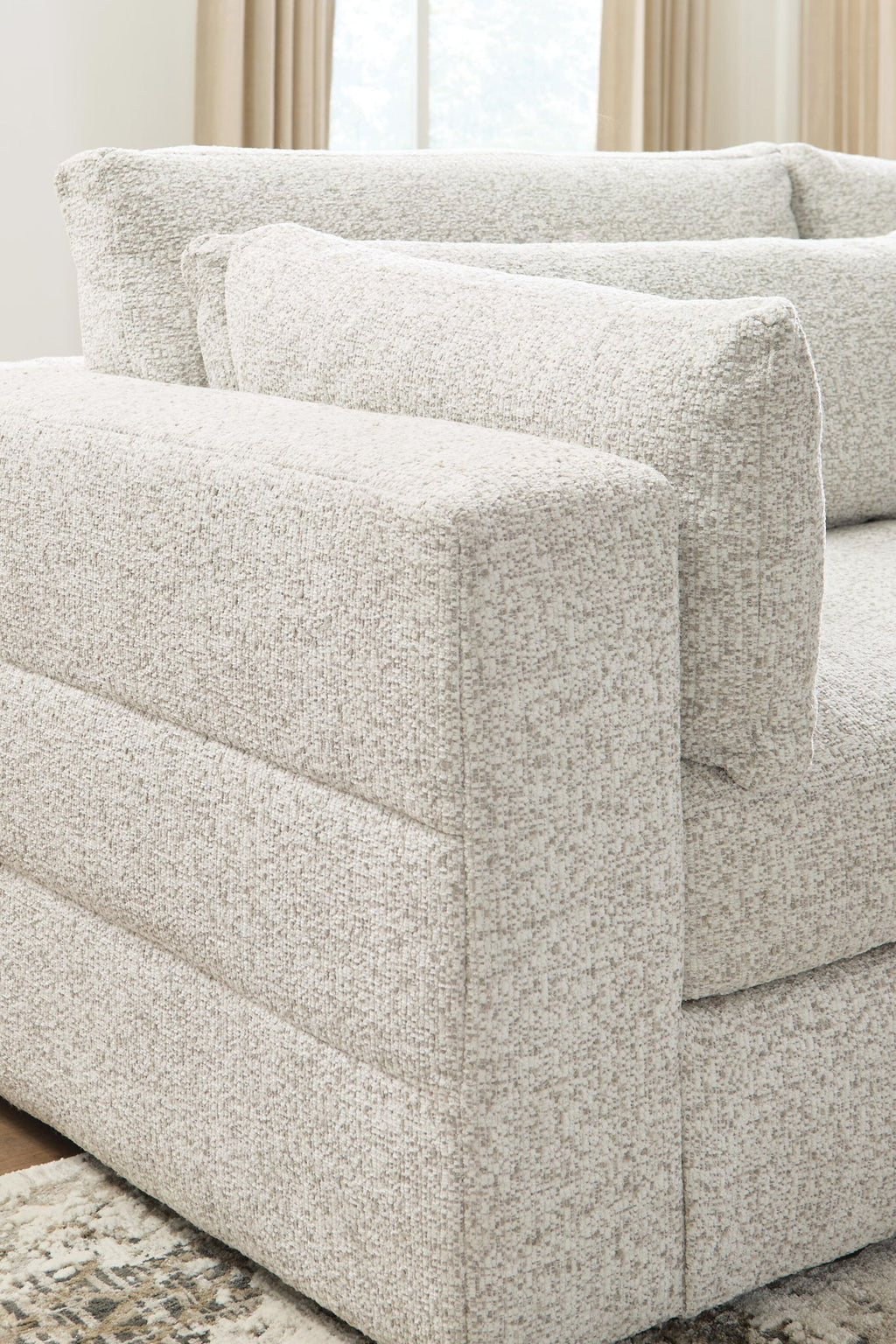 Beige upholstered sectional sofa with squared arm and seat cushion, textured fabric and pillows