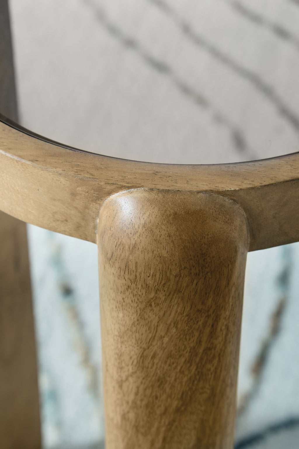 Light brown table leg with rounded foot and visible wood grain texture