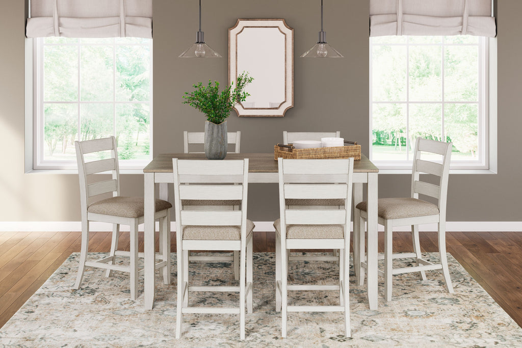 White counter-height dining table with light brown top and six bar stools with beige seats