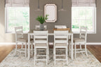 White counter-height dining table with light brown top and six bar stools with beige seats