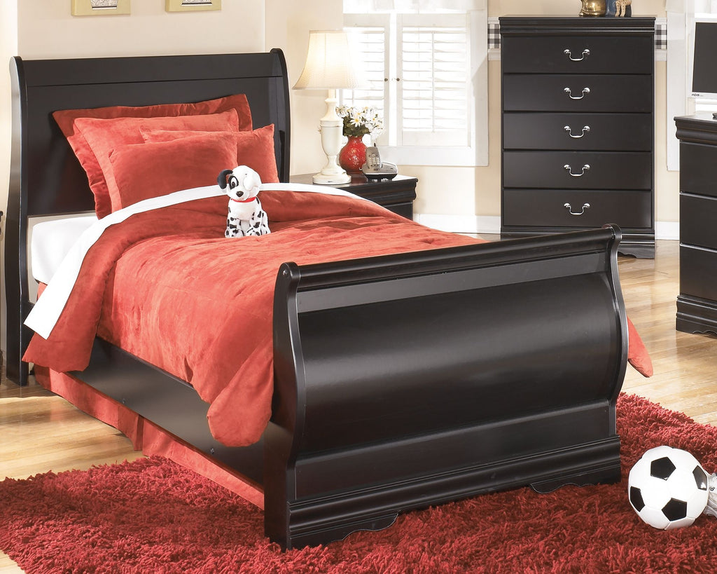 Black youth bed frame with red bedding and curved footboard