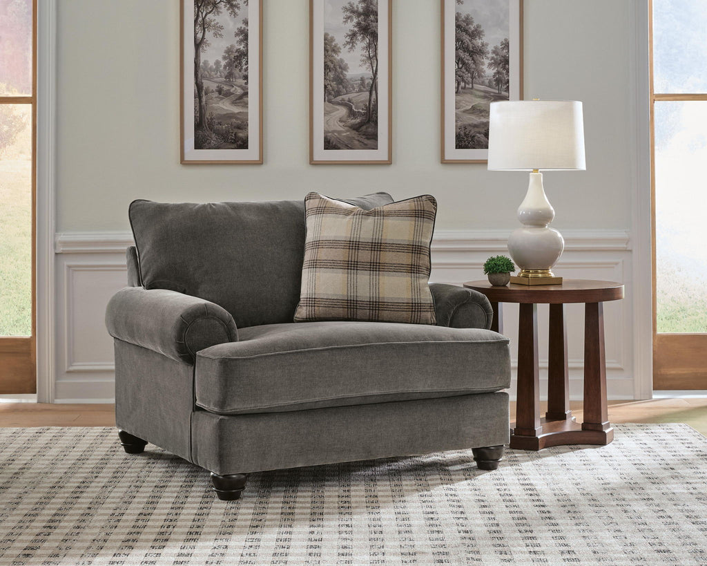 Gray chair-and-a-half with plaid and solid accent pillows and rolled arms
