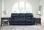 Power reclining sofa with dark navy leather-look upholstery and padded armrests